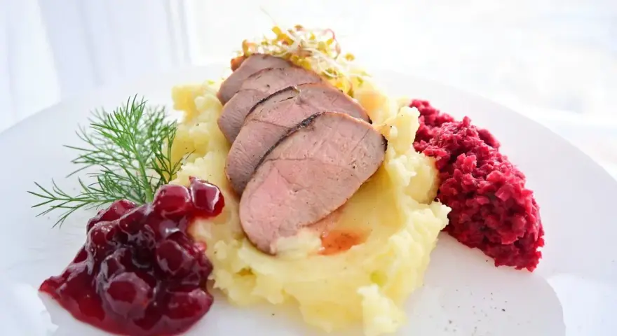 Soczysta pierś z kaczki na purée ziemniaczanym, z żurawiną i buraczkami.