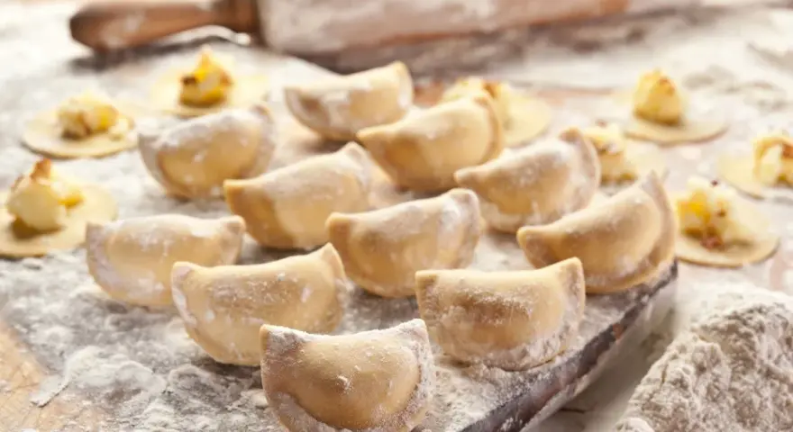 Gotowe do lepienia pierogi, posypane mąką. Zastanawiasz się, jaka mąka na pierogi będzie najlepsza? Ta wygląda idealnie!
