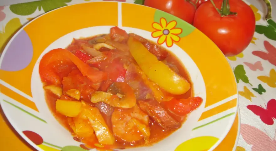 Pyszne leczo z pieczarkami, papryką i pomidorami, podane na kolorowym talerzu.